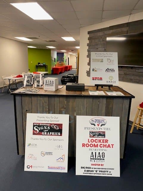Event space with a registration desk featuring sponsor acknowledgment signs.