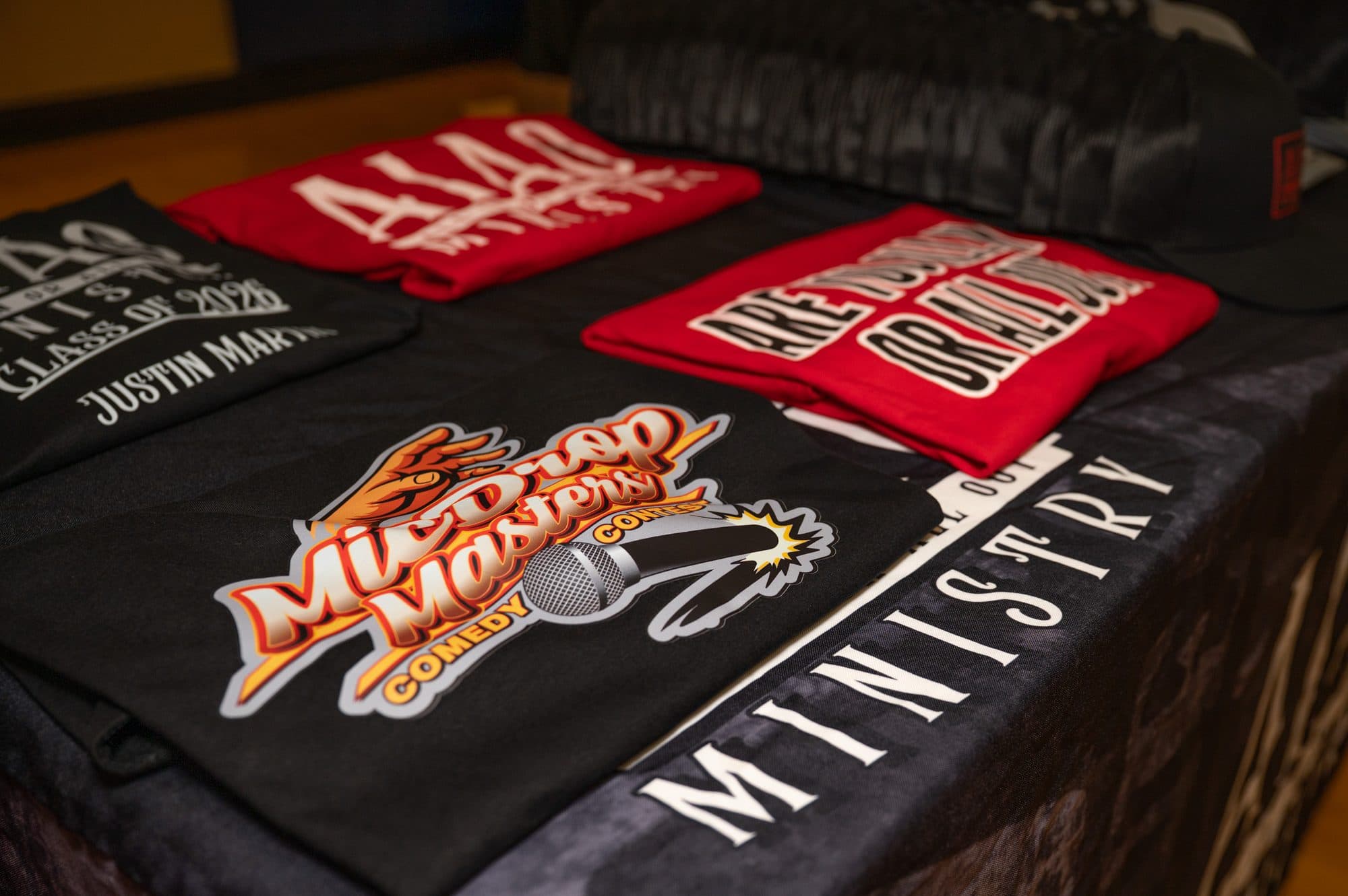 Event merchandise and signage at Mic Drop Masters 2026.