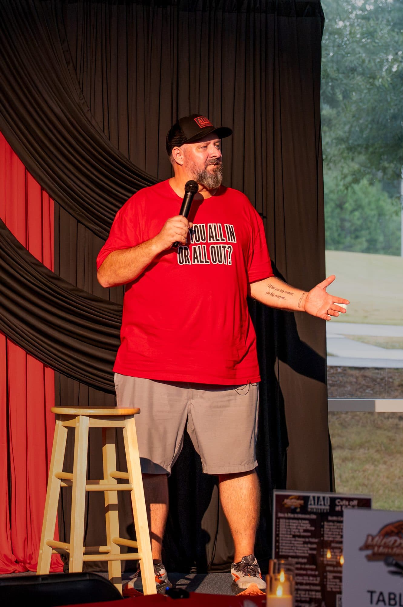 Speaker addressing the crowd at the Mic Drop Masters 2026 fundraiser.