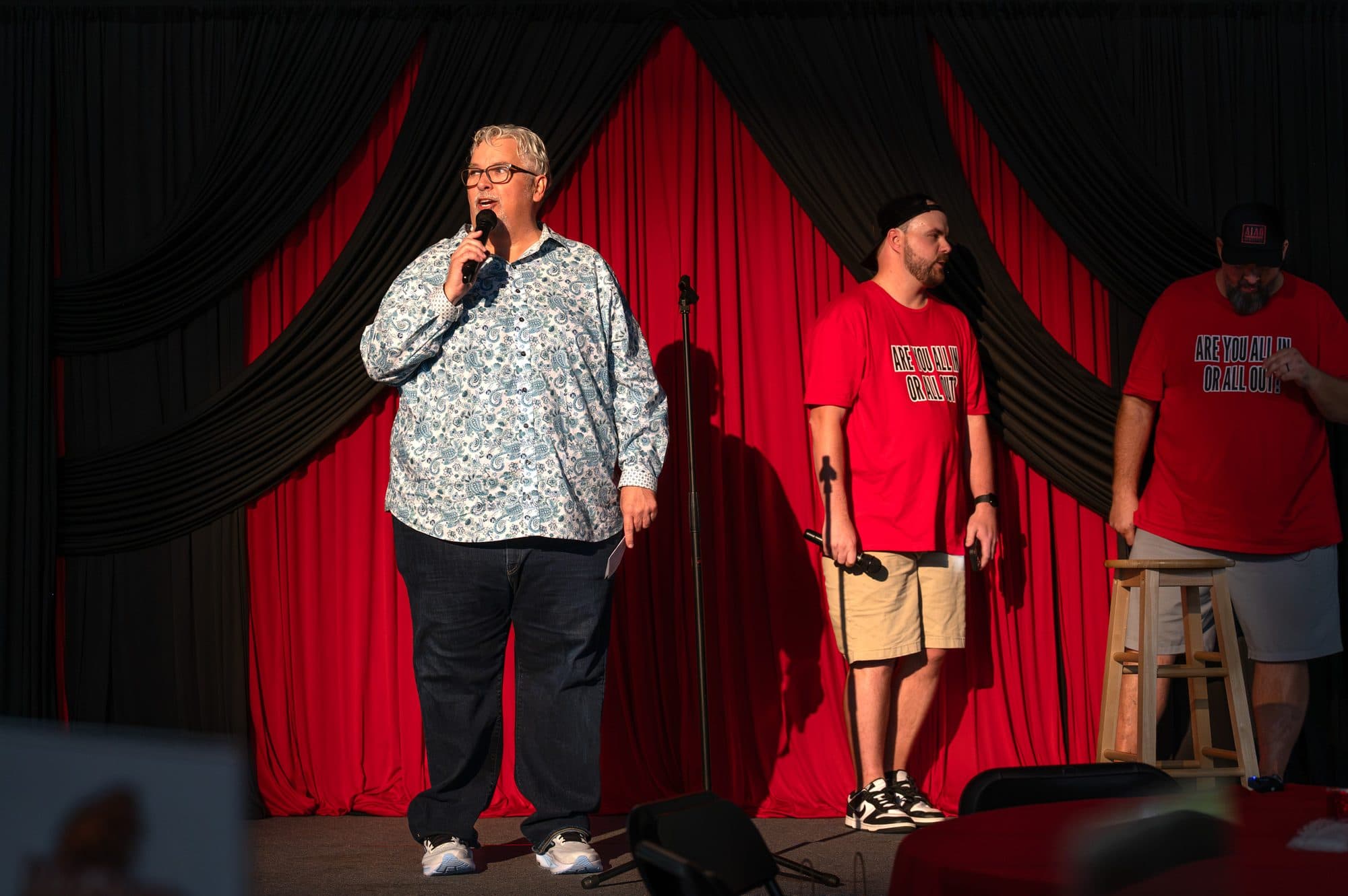 Speaker addressing the crowd at the Mic Drop Masters 2026 fundraiser.