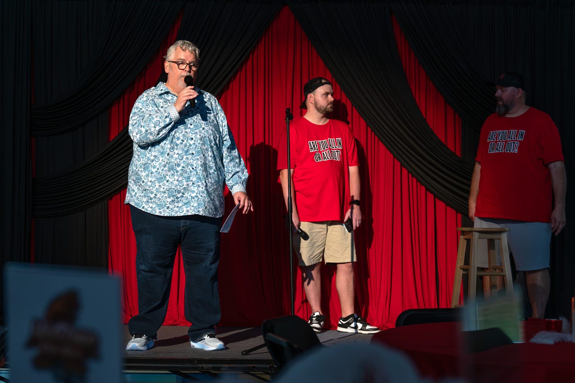 Speaker addressing the crowd at the Mic Drop Masters 2026 fundraiser.